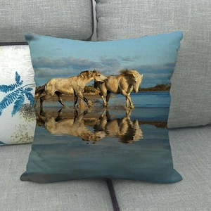 Detailed fabric texture of linen pillowcase featuring running white horses on a sofa