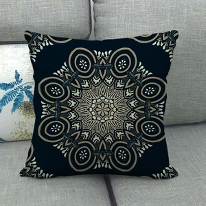 Detail of bohemian mandala pattern on navy blue linen cushion cover on a grey sofa