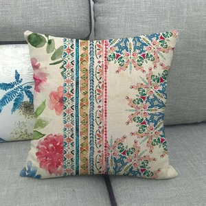 Bohemian geometric linen pillowcase with pink floral and mandala patterns on a grey sofa