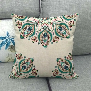 Close-up of bohemian linen pillowcase with peacock mandala pattern on a grey sofa