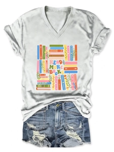 Flat lay of a white V-neck t-shirt with Read More Books colorful print and denim shorts