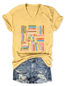 Flat lay of yellow V-neck T-shirt with Read More Books print and ripped denim shorts