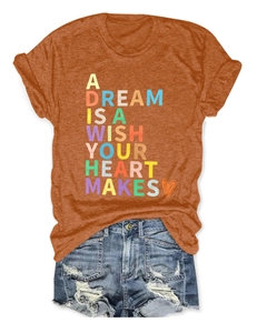 Flat lay of burnt orange crew neck T-shirt with heart graphic and distressed denim shorts