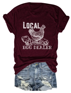 Close-up of Local Egg Dealer print on burgundy t-shirt with distressed denim shorts