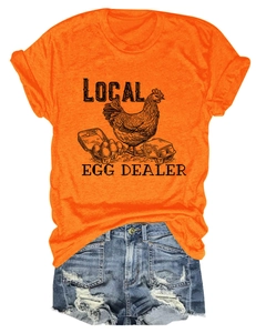 Flat lay of an orange Local Egg Dealer graphic t-shirt with distressed denim shorts