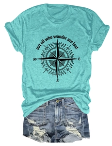Flat lay of a teal compass t-shirt with ripped denim shorts on a white background