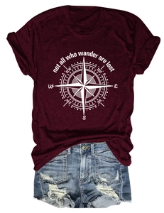 Close-up of compass graphic on wine red t-shirt with denim shorts laying flat