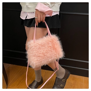 Dettaglio borsa in ecopelliccia rosa con morbida texture e tracolla sottile su una modella