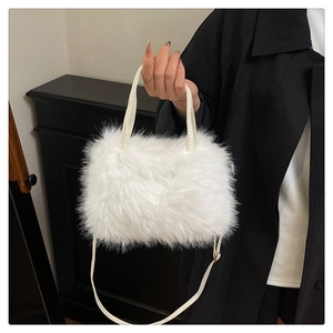 Close-up van de witte pluche imitatiebonttextuur en leren handvat van een chique handtas