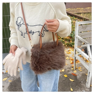 Dettaglio della borsa in peluche marrone con manico in pelle e trama in finta pelliccia