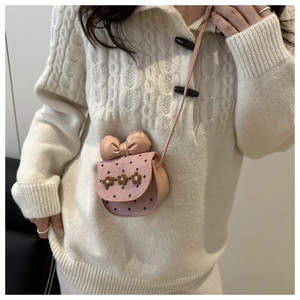 Detailed view of mini pink crossbody bag with knitted flowers and a large leather bow