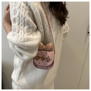Détail d'un mini sac rose en bandoulière avec grand nœud et fleurs décoratives 3D