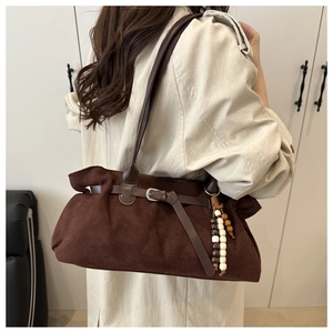 Dettaglio della borsa tote in pelle scamosciata marrone scuro con ciondolo di perline