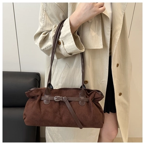 Detailed close-up of dark brown suede tote bag with leather buckle strap and soft texture