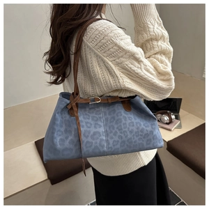 Détail du sac fourre-tout à motif léopard bleu avec anses en cuir et boucle en métal