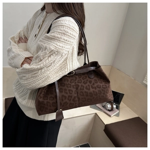Détail du sac cabas léopard avec texture suédine et pendentif décoratif en cuir