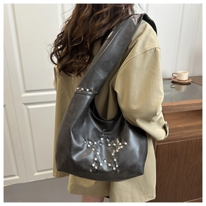 Rear view of a black oversized shoulder bag with star-shaped silver studs on leather