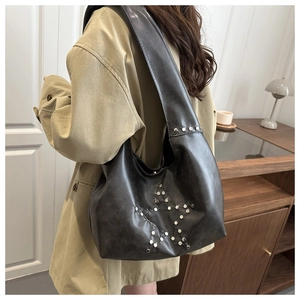 Detail view of black hobo shoulder bag featuring retro silver rivet star pattern