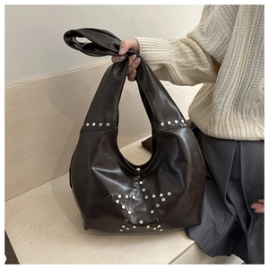 Detail of silver star rivets on dark brown hobo bag with a retro fashion aesthetic