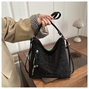 Detail view of the black frosted leather texture and side zipper on this tote bag