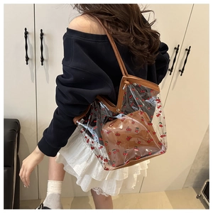 Detailed shot of transparent jelly tote bag with cherry print and brown inner pouch