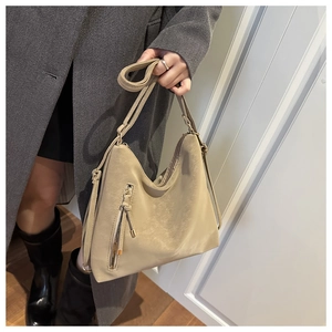 Close-up of khaki retro hobo bag featuring diagonal zipper pocket and tassel details