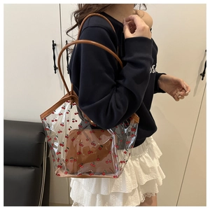 Detailed view of PVC tote bag with cherry print and brown inner pouch on model