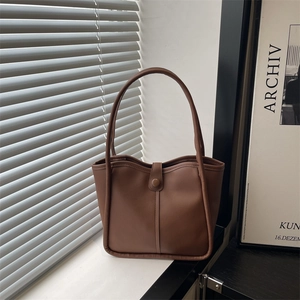 Sac cabas marron vintage en similicuir avec boucle ronde dans un décor minimaliste