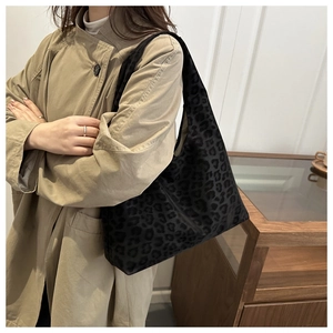 Detailed view of women's leopard print hobo shoulder bag styled with a beige trench coat