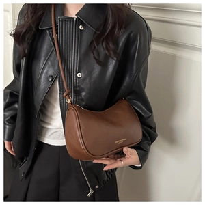 Vue détaillée d'un sac bandoulière en cuir marron foncé en forme de demi-lune