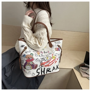 Detail of bear graffiti bucket bag with brown handles on a cozy knit sweater background