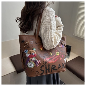 Détail d'un sac seau en cuir marron avec graffiti d'ours et imprimés de lettres