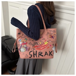 Pink graffiti bucket bag with teddy bear prints worn by a model in a modern room