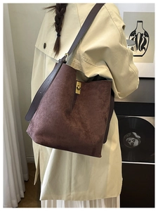 Detailed view of brown matte leather tote bag with elegant gold metal twist lock buckle