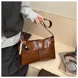 Dettaglio borsa tote vintage marrone in pelle lucida con ciondolo a nappine di perle