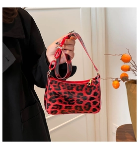 Detail of red leopard print handbag with glossy finish and bold decorative chain link