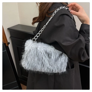 Detailed view of grey faux fur shoulder bag with silver metal chain worn with black coat