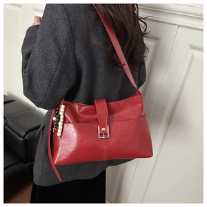 Dettaglio borsa tote in pelle rossa con fibbia argento e perline di legno bianco e nero