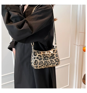 Detail of trendy leopard print baguette bag with glossy finish on a shoulder strap