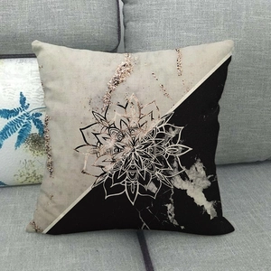 Detail of bohemian mandala throw pillow cover with golden glitter pattern on grey sofa