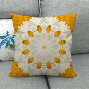Detail of yellow linen pillowcase with white daisy geometric pattern on a grey sofa
