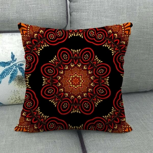 Detailed view of square bohemian pillow with red and black mandala patterns on sofa