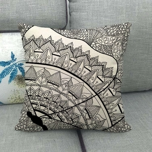 Dettaglio del copricuscino in lino con motivi mandala e grafiche di animali neri