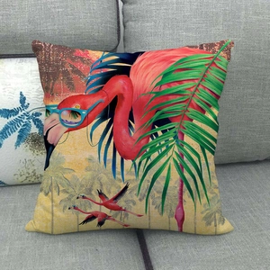 Close-up of linen pillow cover featuring a pink flamingo with glasses on a grey sofa