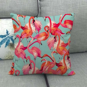 Close-up of pink flamingo pattern on linen throw pillow cover on a grey sofa