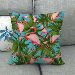 Pink flamingo and palm leaf linen pillow cover on a gray sofa for tropical home decor