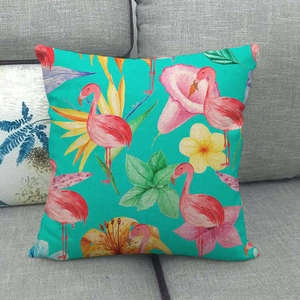 Linen flamingo pillow cover on a grey fabric sofa with tropical flowers print