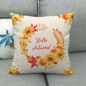 Détail de la housse de coussin en lin avec couronne d'automne sur un canapé gris