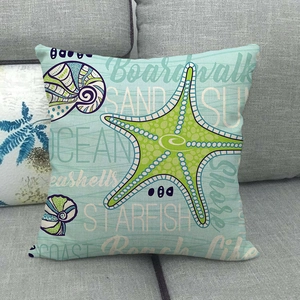 Linen ocean theme cushion cover with green starfish print on a soft grey sofa