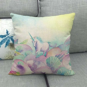Gros plan sur la housse de coussin en lin montrant une licorne et des motifs aquarelle